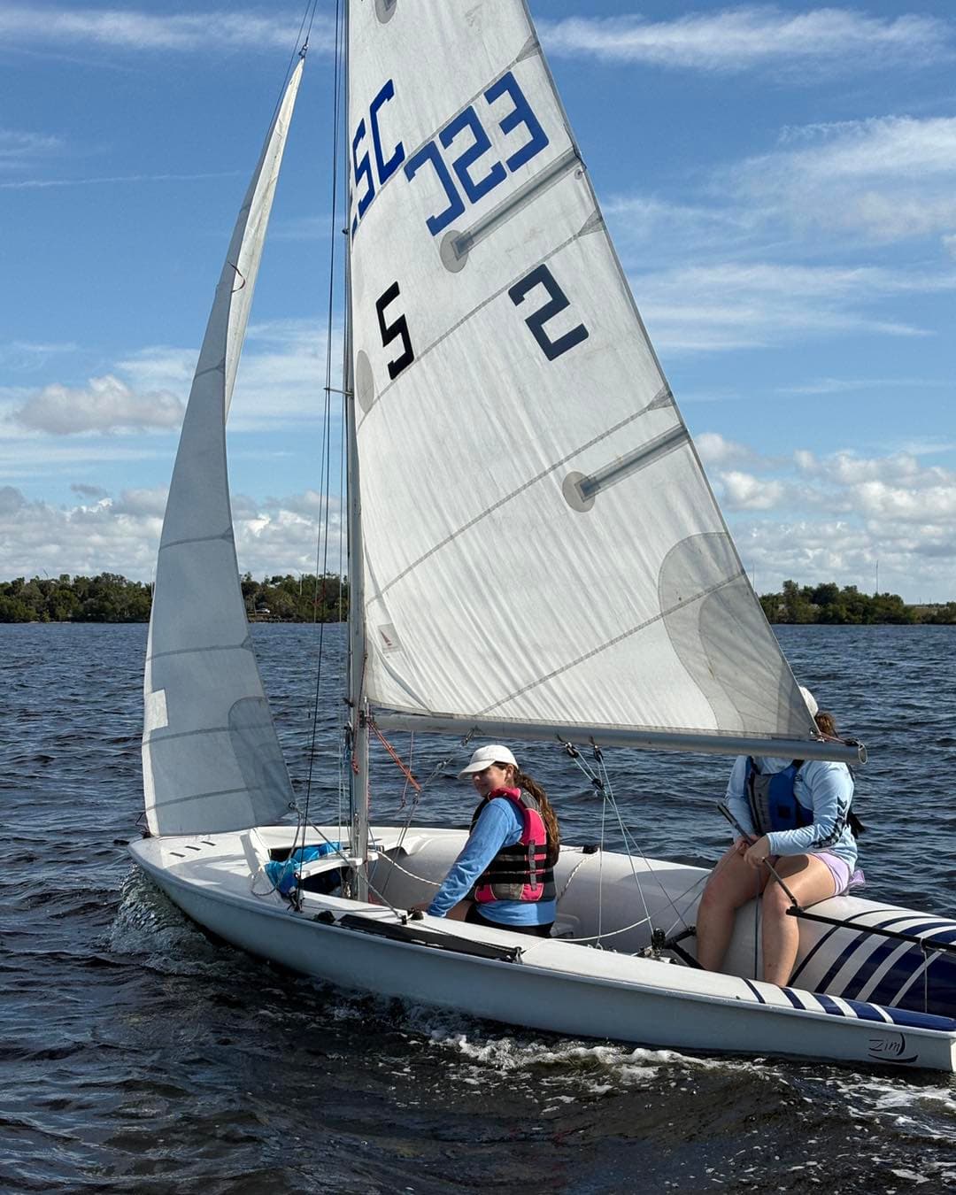 Two sailors racing a 420 on the river