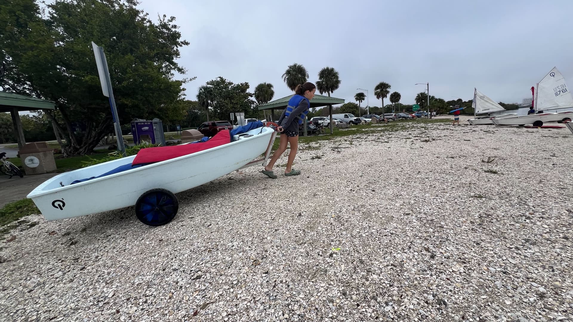 Girl hauling a boat on the beach