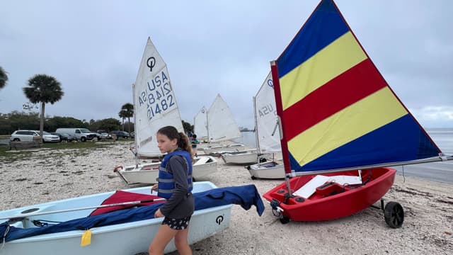 Girl in lifejacket with colorful sail