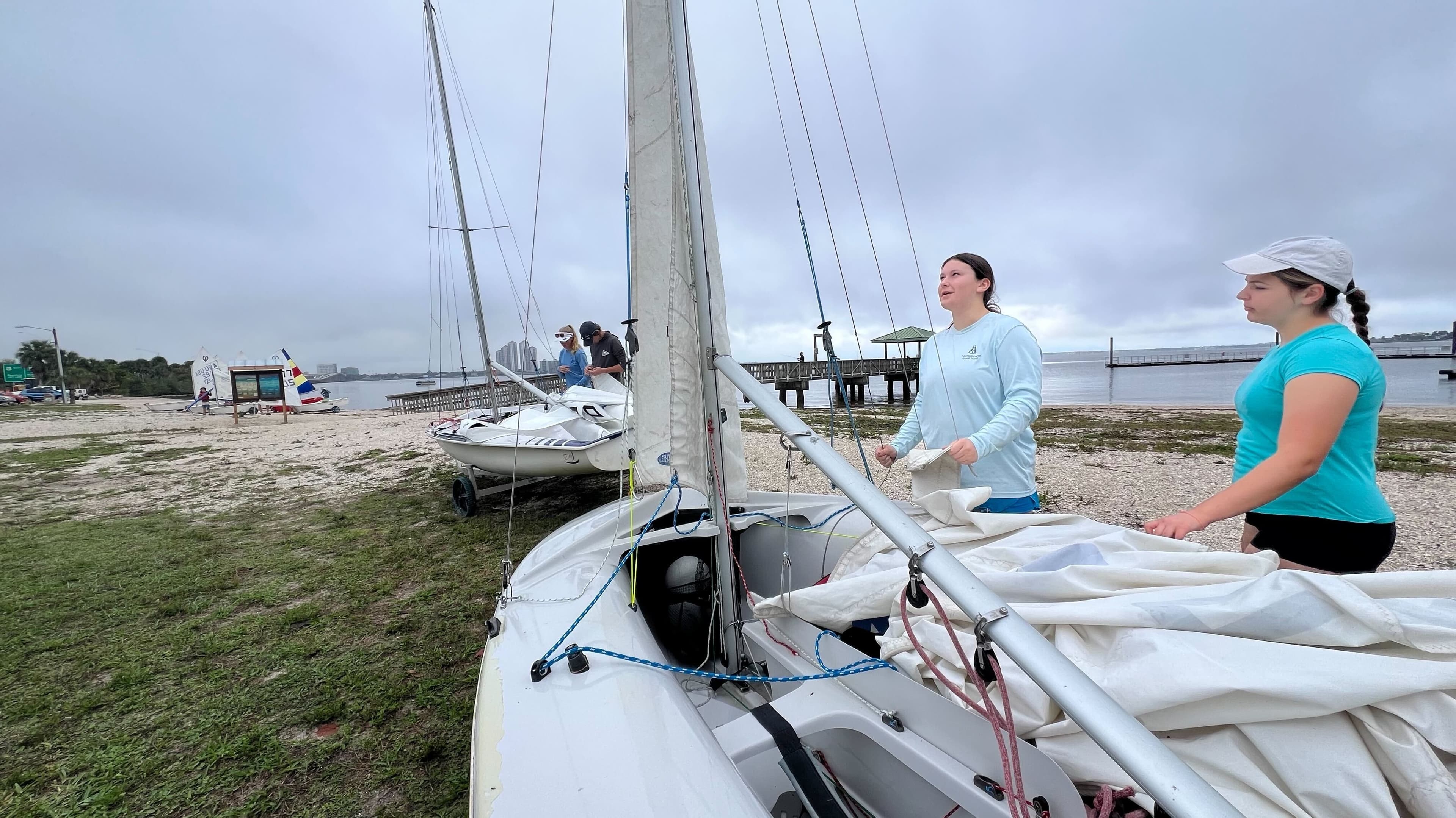 Teens rigging sailboats together