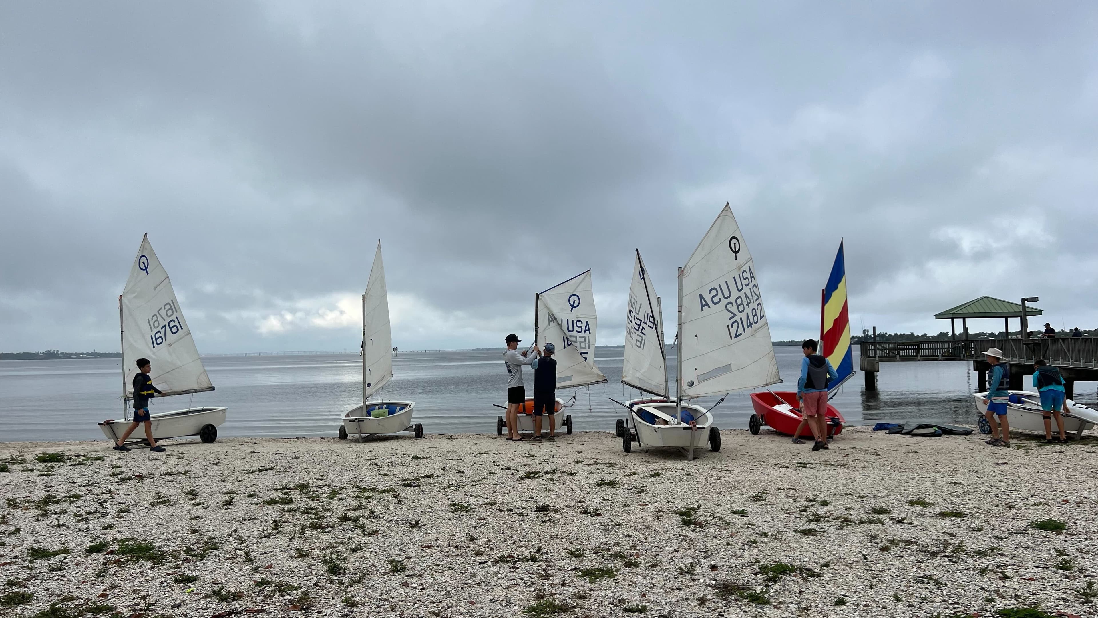 Young sailors rigging boats on the beach